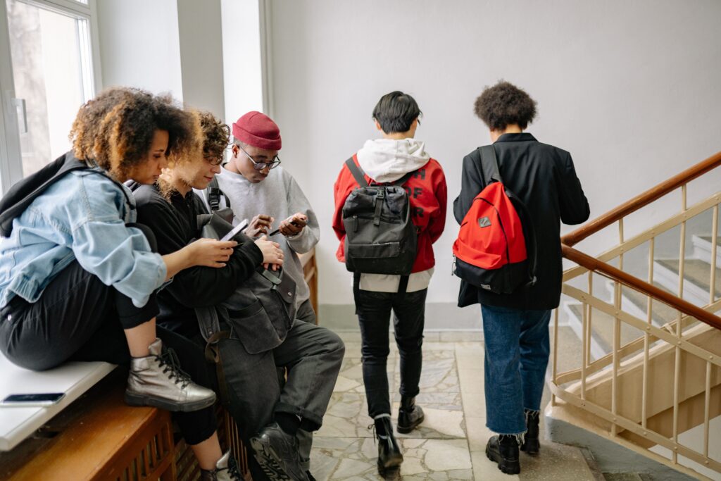 カナダで学生たちがスマホを階段の踊り場で使っている様子