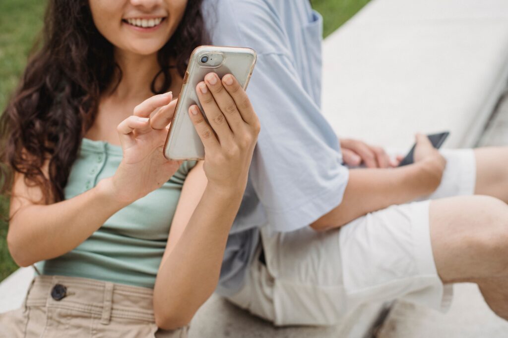 男性と女性が笑顔でスマホを触っている様子